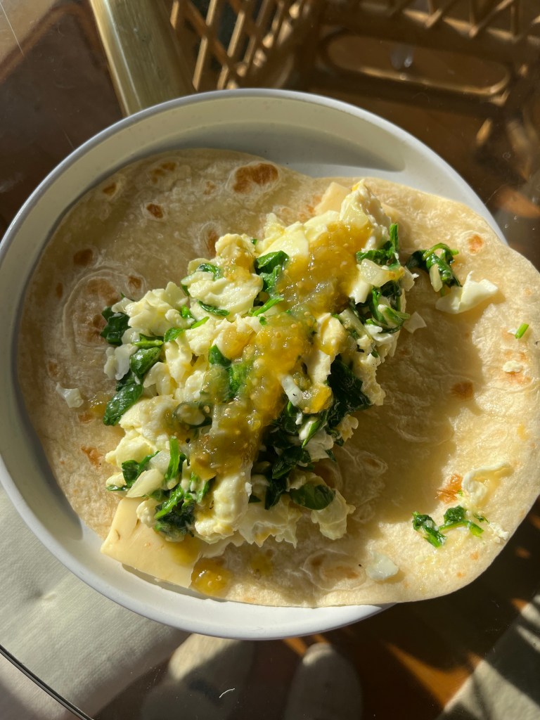 A plate with an open tortilla filled with an egg scramble.