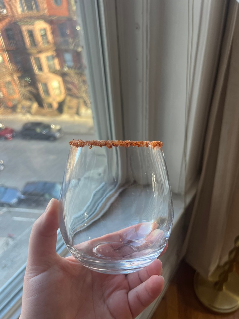 A stemless wine glass rimmed with Tajin.